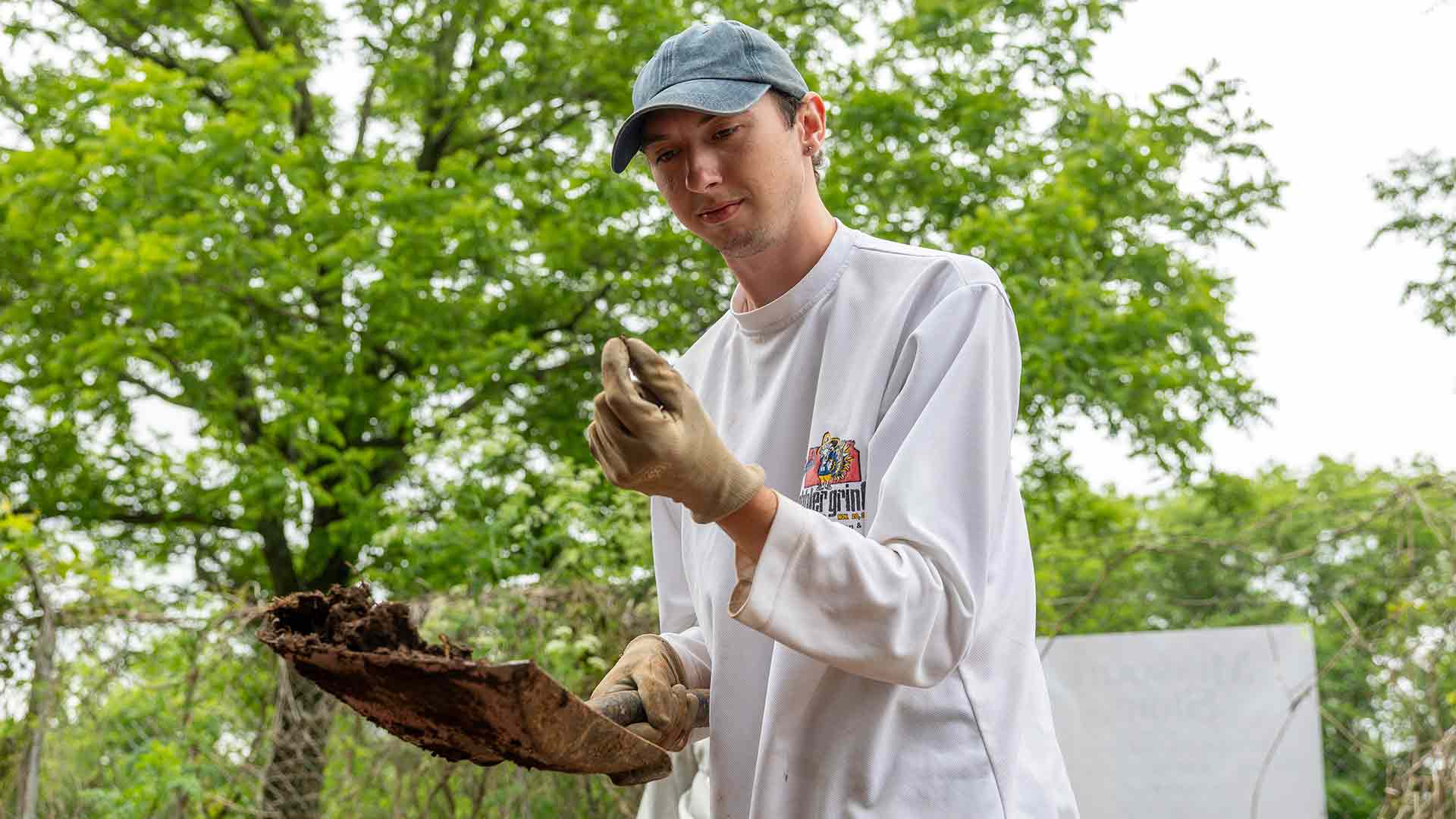 A student examines findings from an archaeological dig at Nathanael Greene Park  in Springfield.