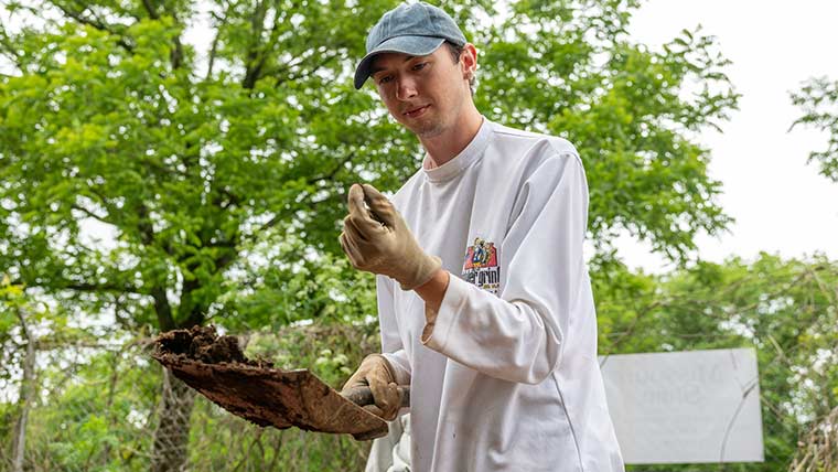 A student examines findings from an archaeological dig at Nathanael Greene Park  in Springfield.