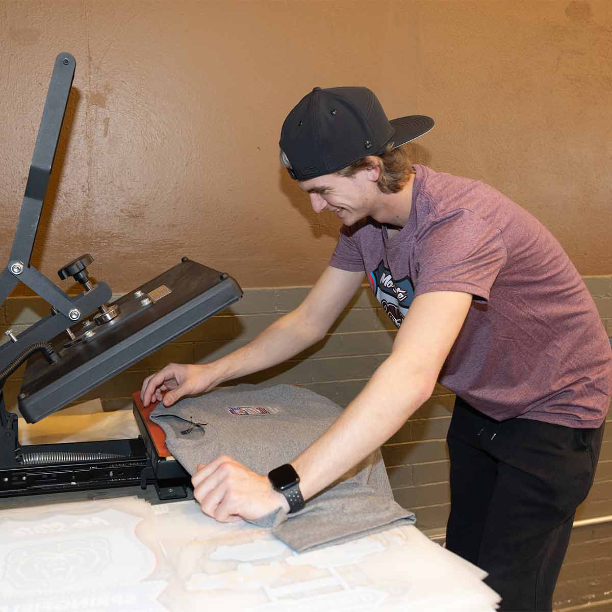 Student doing a screenprint on a t-shirt.