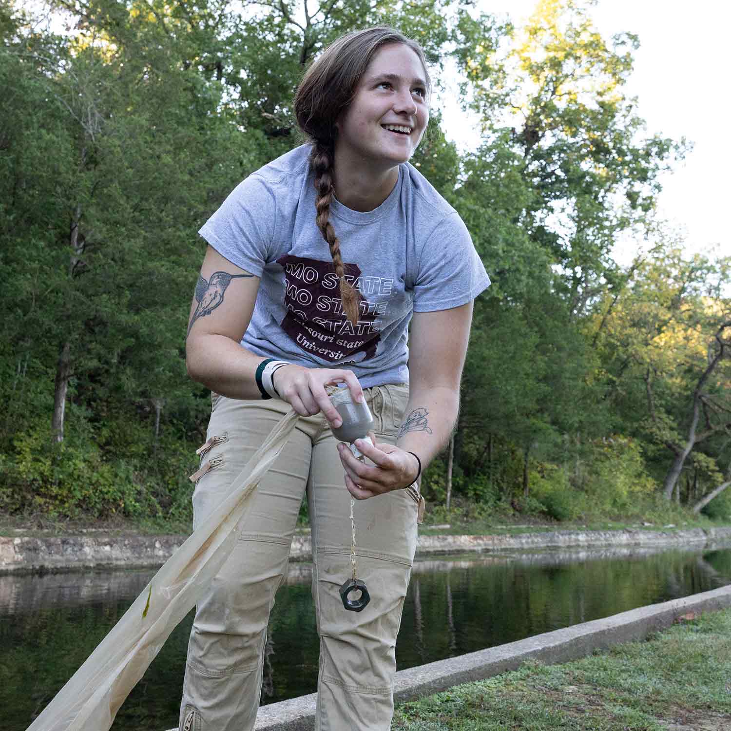 A student colllects water samples from a pond at Sequiota Park in Springfield.